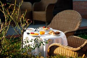 a table with plates of food and orange juice at Phi Hotel Emilia in Ozzano dell'Emilia