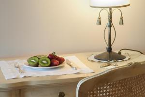 un plato de fruta en una mesa con una lámpara en La Corte di Opaka en Canosa di Puglia