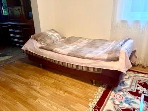 ein Bett in einem Zimmer mit Holzboden in der Unterkunft Apartment Panonija in Tuzla