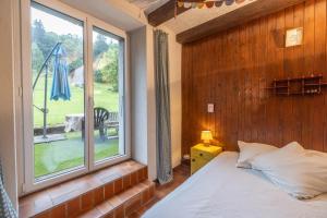 a bedroom with a bed and a large window at Magnifique Chalet aux Carroz in Arâches-la-Frasse