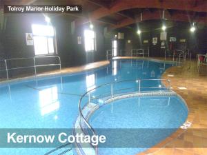 a large swimming pool in a building with the words know cottage at Tolroy Manor - 84 Strawberry Hill in Hayle
