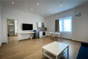 a large living room with a table and a kitchen at Monumental Luxury Rooms in Caserta