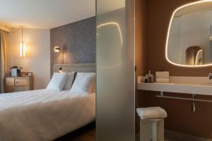 a hotel room with a bed and a sink at Oceania Saint Malo in Saint Malo