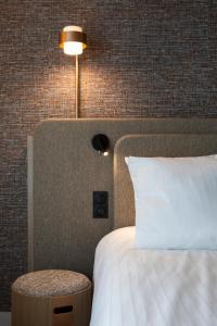 a bedroom with a bed and a lamp and a table at Oceania Saint Malo in Saint Malo