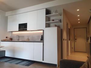 a kitchen with white cabinets and a refrigerator at Dervio Casa Max in Dervio