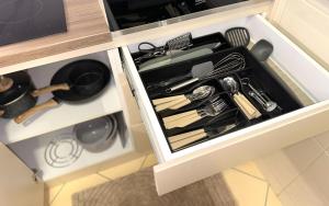 a drawer filled with cooking utensils in a kitchen at LU Apartment in Novi Sad +13 photos