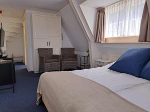 デ・コーフにあるHotel Het Gouden Boltjeのベッドルーム1室(ベッド1台、椅子2脚、窓付)