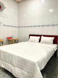 un grande letto bianco in una stanza con due tavoli di Nhà Nghỉ Tấn Phát a Ấp Thanh Sơn (1)