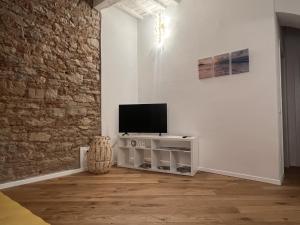 a living room with a tv on a white wall at luxury apartment centro storico in Piombino