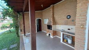 a brick building with a kitchen and a fireplace at Casa Itaguá in Ubatuba