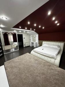 a bedroom with a large white bed and a mirror at Casă de vacanță in Ocniţa +51 photos