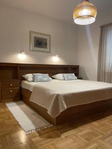 a bedroom with a large bed and a chandelier at Apartment Capitano in Slatine