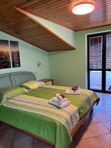 a bedroom with a large bed with towels on it at Apartma Mimi in Dekani