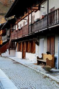a building with wooden doors and a bench on a street at Ferrata Vacanze in Rhêmes-Notre-Dame