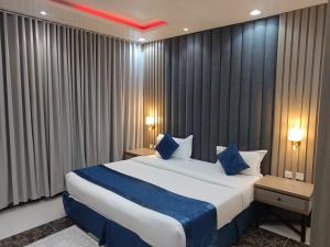 利雅德Diafa Saadet Serviced Apartments- Qurtopa 1的卧室里有一张大床，配有蓝色枕头