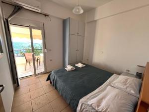 a bedroom with a bed and a view of a balcony at Eirini Apts On the beach in Psari Forada