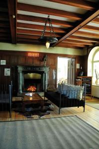 - un salon avec une cheminée, un canapé et une table dans l'établissement Grinda Wärdshus, à Grinda