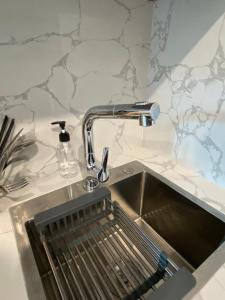 a kitchen sink with a faucet on a counter at The Eudora Homestay in An Khê