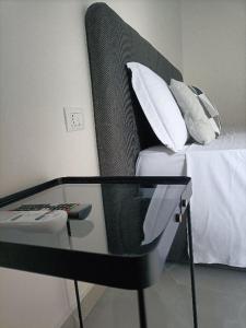 a glass table in front of a bed with pillows at B&B Carpe Diem 2 in Caserta