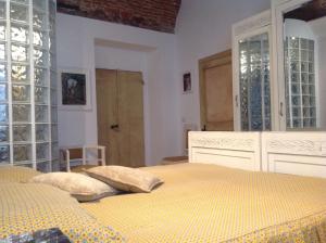 ライグエーリアにあるApartment Piazza XXV Aprileのガラスドア付きの部屋のベッド1台が備わるベッドルーム1室です。