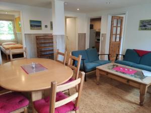 un salon avec une table, des chaises et un canapé dans l'établissement Ostseenaher Bungalow mit überdachter Terrasse, à Wobbelkow