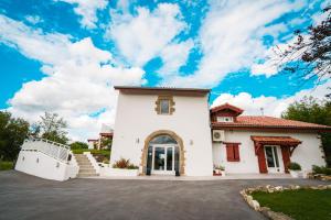 a large white house with a driveway at Bed & Breakfast Perbos 1556 in Labastide-Clairence