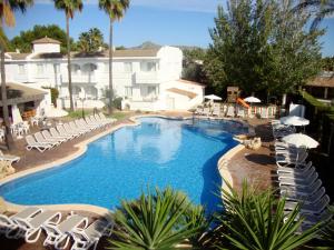 a swimming pool with lounge chairs and a hotel at Apartamentos Solecito in Port d'Alcudia