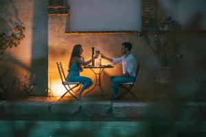 a man and woman sitting at a table drinking wine at Relais Conac 1888 - Luxury B&B - Adults Only in Castelnuovo Don Bosco +69 photos