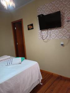 アウト・パライーゾ・デ・ゴイアスにあるPousada Praça do Bambuのベッドルーム1室(ベッド2台、壁掛け式薄型テレビ付)