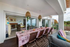 una sala da pranzo e una cucina con tavolo e sedie di Luxurious BEACHFRONT VILLA de la PLAGE with private beach acces ad Albufeira