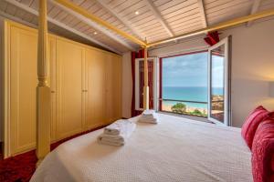 una camera da letto con un letto con vista sull'oceano di Luxurious BEACHFRONT VILLA de la PLAGE with private beach acces ad Albufeira Altre 219 foto