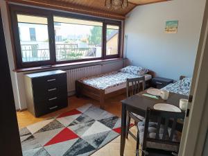 a room with two beds and a table and a window at VillaMaria in Gdańsk