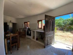 a kitchen with a door open to a kitchen with a table at Casa Circular in Tatajuba