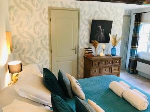 a bedroom with a blue bed with pillows and a table at BnB Golden Delicious for 2 in Normandy in Les Champeaux