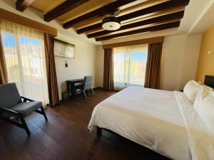 a bedroom with a bed and a chair and windows at Hotel Casa Rubio in Atotonilco el Alto