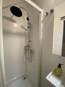a shower with a shower head in a bathroom at Studio pieds des pistes - Cosy & Confort in Ustou
