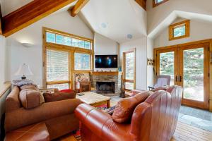 a living room with a leather couch and a fireplace at Quittin' Time on the Woodside in Park City