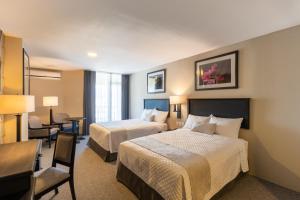 a hotel room with two beds and a desk at Conquistador Hotel & Conference Center in Guatemala +23 photos