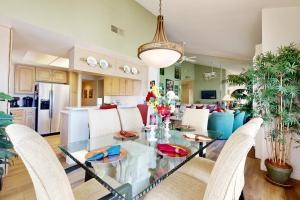 a dining room and kitchen with a glass table and chairs at Riviera Manor Permit# 68147 in La Quinta