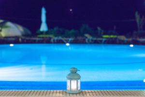 a glass jar with a light next to a swimming pool at Kalimera Hotel in Akrotiri