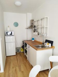 a small kitchen with a sink and a refrigerator at Prechodná stanica in Brezno