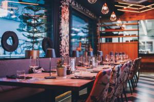 długi stół w restauracji z krzesłami i okularami w obiekcie 24 by AvenidA - Mountain Hotel w Kaprunie