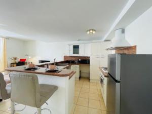 a kitchen with white cabinets and a refrigerator at Le Duplex - Hyper Centre-Ville - 6 voyageurs in Le Mans +7 photos
