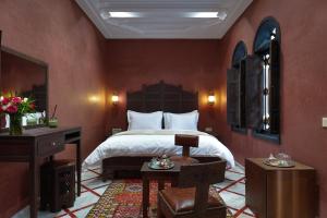 una camera da letto con un letto e una scrivania e un letto sidx sidx sidx di Alrashid Marrakech Boutique Hotel & SPA a Marrakech Altre 86 foto