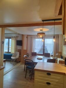 a kitchen and dining room with a table and chairs at Peisey Vallandry, L'appartement au pied des pistes in Landry +10 photos