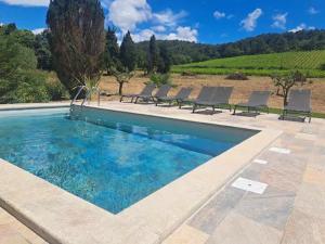 a swimming pool with chairs and a view of a vineyard at Gites L INSTANT PRESENT CHEZ LO in Visan +4 photos