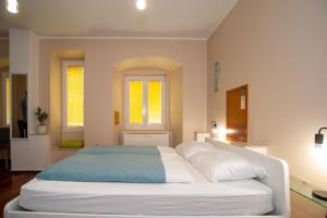 a large white bed in a room with two windows at Tisa & Neo in Rijeka