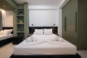 a bedroom with a large bed with white sheets at Euphoria Apartments in Sarandë