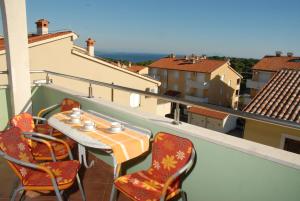 a table and chairs on a balcony with a view at Apartments Green Village in Premantura