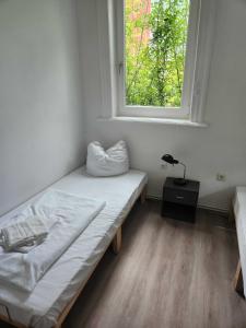 a small room with a bed and a window at Monteurwohnungen Lerbachtal in Osterode
